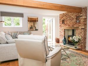 a living room with a couch and a fireplace at 2 Great Tangley Barns in Guildford