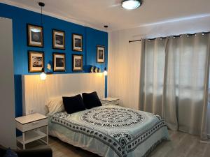 1 dormitorio con paredes azules y 1 cama con almohadas en CORNELIAS HOME TC1 vista marina, en Los Cristianos