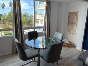 a dining room with a glass table and chairs at CORNELIAS HOME TC1 playa in Los Cristianos +4 photos