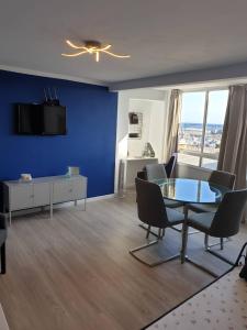 sala de estar con pared azul, mesa y sillas en CORNELIAS HOME TC1 vista marina, en Los Cristianos
