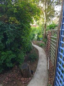 a garden with a fence and a walkway at UppaTree Cottage in Benoni