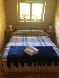 a bedroom with a bed with two towels on it at Domek na wyłączność z dużym ogrodem in Jabłonka