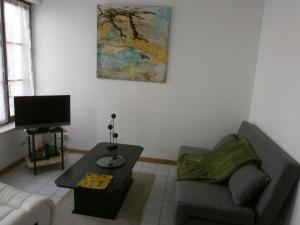 a living room with a couch and a table at Meublé de tourisme L'Eau Vive classé 2 étoiles in Plombières-les-Bains