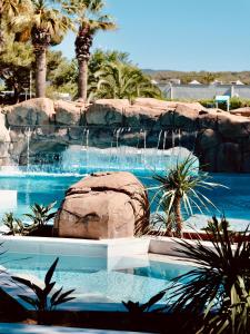 una piscina con cascada en un complejo en HolaCamp Sitges Garrofer, en Sitges