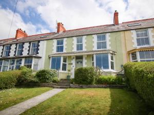 an old house with a lawn in front of it at Gorphwysfa in Cemaes Bay