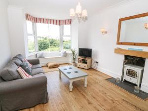 a living room with a couch and a fireplace at Gorphwysfa in Cemaes Bay