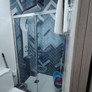 eine Dusche im Bad mit blauen Fliesen in der Unterkunft Apartamentos Sol y Luna Conil in Conil de la Frontera