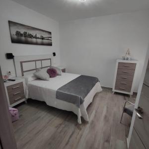 ein Schlafzimmer mit einem Bett und einer Kommode in der Unterkunft Apartamentos Sol y Luna Conil in Conil de la Frontera