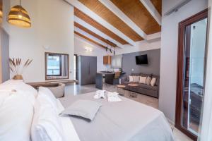 a bedroom with a white bed and a living room at Trizonia Bay Hotel in Trizonia