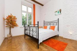 a bedroom with a black bed with orange pillows at Urban Nest Apartments Dietla 69-8B in Kraków