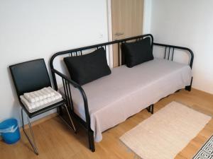 a black and white bed with two pillows and a stool at Energy Lodge in Kandersteg