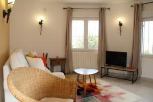 ein Wohnzimmer mit Couch und Fernseher in der Unterkunft Casa León with private pool great view in Benissa