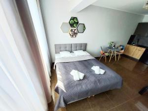 a bedroom with a bed with pillows and a table at Apartament PLANETA MIELNO - centrum, 2 minuty od plaży ! ! ! in Mielno