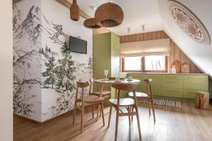 een keuken en eetkamer met een tafel en stoelen bij Willa Dunajec - Luxury Apartments in Zakopane