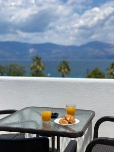 una mesa con dos vasos de zumo de naranja y un plato de comida en Billys apartment Selianitika, en Selianitika