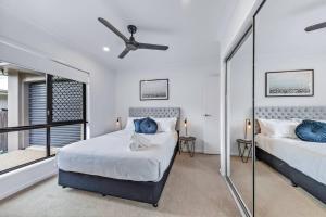 a bedroom with two beds and a window at Airlie Beach Home in Airlie Beach