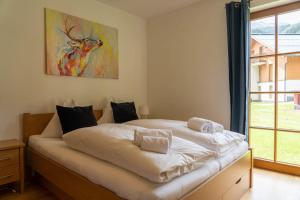 a bed in a room with a painting on the wall at Andrea 1 by SMR Rauris Apartments inc SPA and National Summercard - near Gondola in Rauris