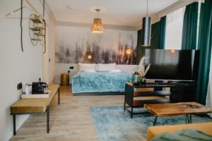 uma sala de estar com uma cama e uma televisão em Peak Hotel & Event em Salzgitter
