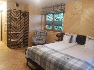 Un dormitorio con una cama y una silla dentro. en Apartamenty BENITA, en Zakopane