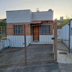 a house behind a fence with a gate at Casa Terras Altas in Juiz de Fora