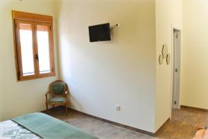 a bedroom with a bed and a tv on a wall at Casa Bienvenida - Carcaixent in Carcagente