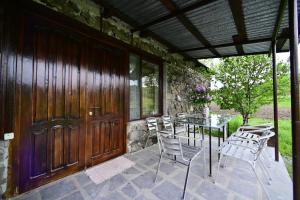 patio con mesa, sillas y puerta de madera en Sevan Tarsus Guesthouse, en Tsovazard