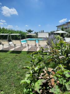 een rij stoelen naast een zwembad bij Appartamenti Villa Gloria in Peschiera del Garda