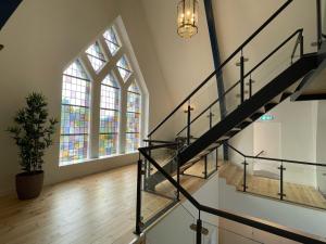 a staircase leading up to a balcony with a clock on it at Woonhotel Petruskerk in Vlissingen