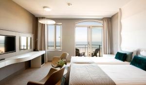 a hotel room with a view of the ocean at Strandhotel Golfzang in Egmond aan Zee