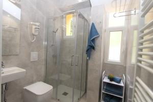 ein Bad mit einer Dusche, einem WC und einem Waschbecken in der Unterkunft L APARTMENT in Raša