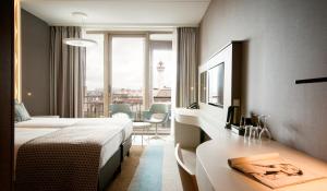 ein Hotelzimmer mit 2 Betten und einem Schreibtisch mit einem Tisch in der Unterkunft Strandhotel Golfzang in Egmond aan Zee