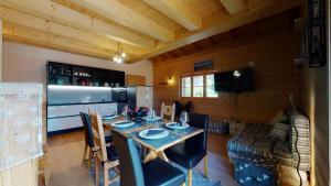 una sala da pranzo con tavolo e sedie in una cabina di Chalet des Alpes NATURE & MOUNTAIN by Alpvision Résidences a Prarion