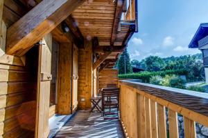 a porch of a log cabin with stools on it at Apartment Chalet des Granges in Les Houches