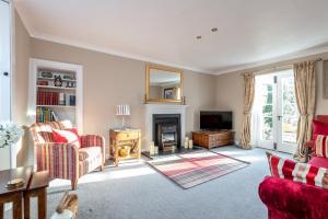a living room with a fireplace and a tv at Charming Cardoon Cottage in beautiful village in Comrie