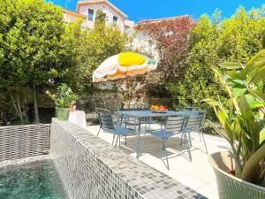 un patio con mesa, sillas y sombrilla en La Maison du Vallon, en Marsella