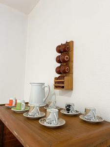 a table with cups and saucers and donuts on it at Hostel Villa Virtudes in Guarapari