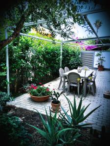 een patio met een tafel, stoelen en planten bij Dimora Deva in Pescara