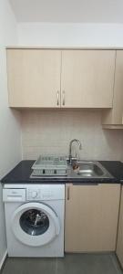 a kitchen with a sink and a washing machine at Valentinas apartment ! in Polis Chrysochous