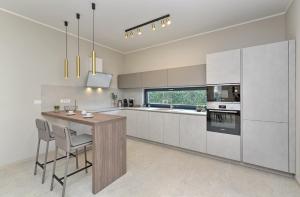 a kitchen with white cabinets and a table and chairs at New VILLA TIHI OTOK near the beach in Fažana