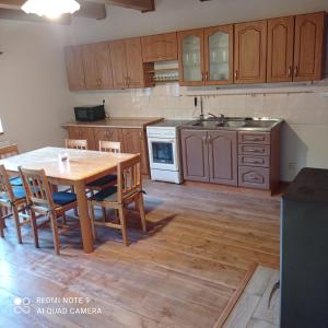 una cucina con tavolo in legno e armadi in legno di Chata Vidlák a Černíny