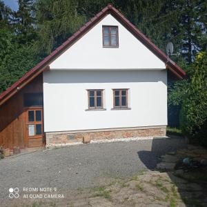 una casa bianca con tetto rosso di Chata Vidlák a Černíny