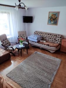 a living room with a couch and a table at Dom Wypoczynkowy Jaworzynka in Tylicz