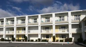 約克的住宿－Sunrise Motel，带阳台的白色公寓大楼和停车场