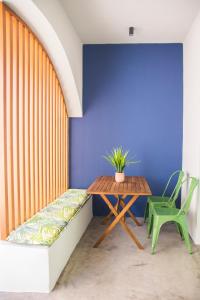 una mesa y un banco en una habitación con una pared azul en Siroa Easy, en Ermoupoli