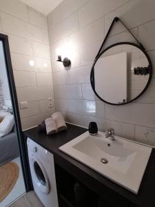 a bathroom with a sink and a washing machine at Appartement centre ville avec parking privatif in Dijon