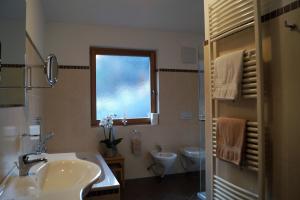 a bathroom with a sink and a toilet and a window at Haus Maiern in Ridanna