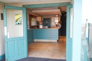 un ingresso a un ristorante con porta blu di The Royal Hotel a Whitley Bay