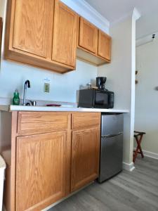 a kitchen with wooden cabinets and a microwave at Sunrise Motel in York