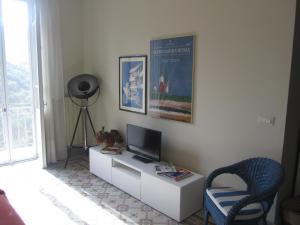 een kamer met een bureau, een televisie en een stoel bij La Felice Casa Di Nonno Battistino in Apricale