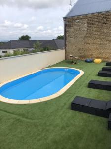 une grande piscine bleue sur une pelouse verdoyante dans l'établissement Les villas d'Hannogne, à Hannogne-Saint-Martin